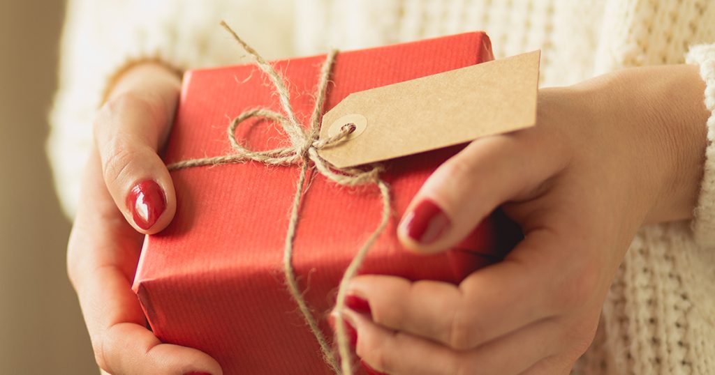 Girl holding red box of christmas present