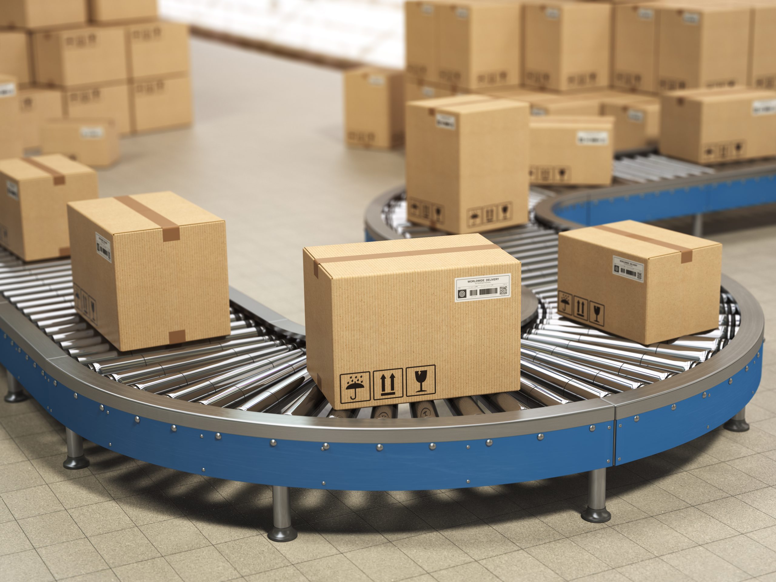 Cardboard boxes on conveyor roller in distribution warehouse